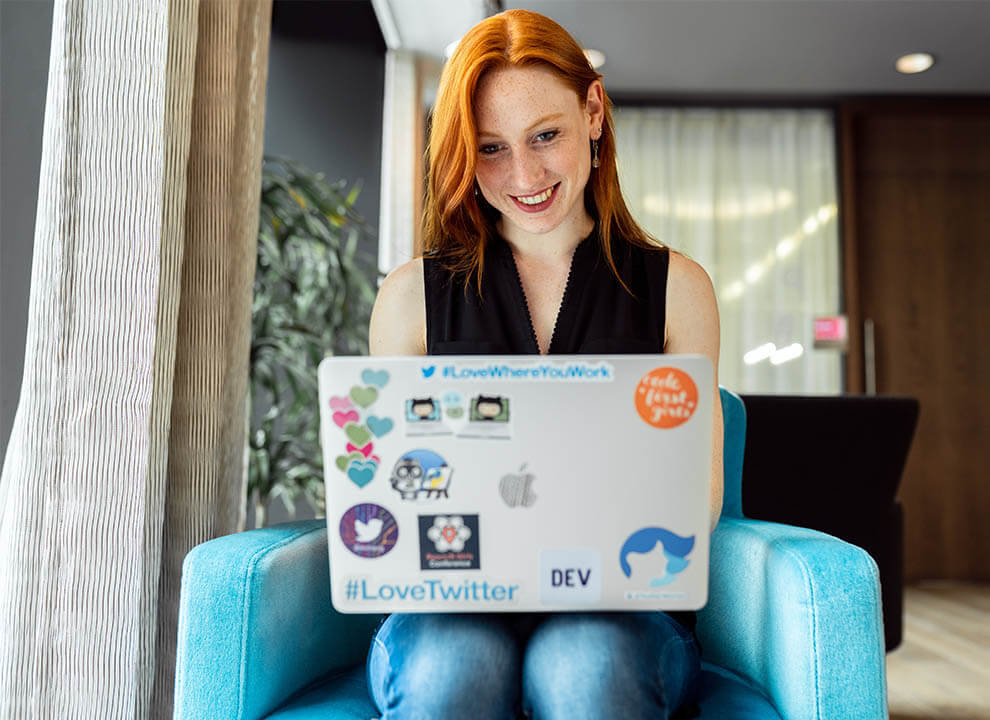 A developer behind her laptop smiling