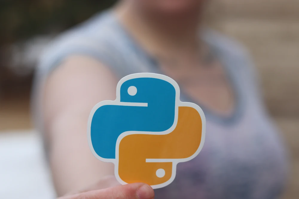 A hand holding the Python logo